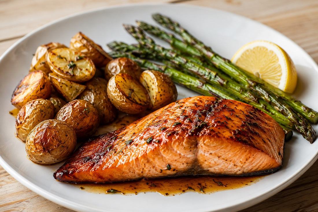 Filet de saumon au four assaisonné avec Le Canadien de Mélanges Austin Blends, servi avec citron, asperges grillées et pommes de terre rôties.